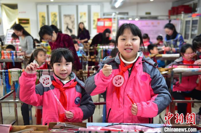 圖為小學(xué)生展示繡制好的2022年北京冬奧會(huì)吉祥物“冰墩墩”形象?！∮髟屏?攝