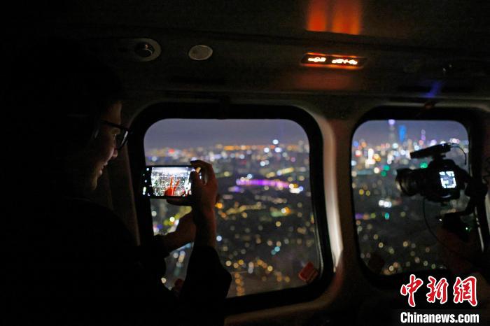 6月3日晚，游客乘坐上海新空直升機有限公司直升機開啟鳥瞰黃浦江空中圓夢之旅，并用手機拍攝城市夜景。　殷立勤 攝