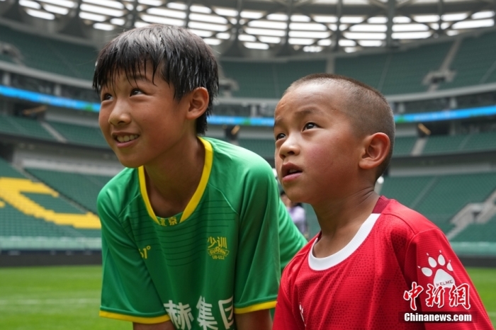 圖為北京國安小球員陳小北和7歲的俄金仁增在一起觀看場內(nèi)播放的紀錄片。<a target='_blank' href='/' _fcksavedurl='/'><p  align=