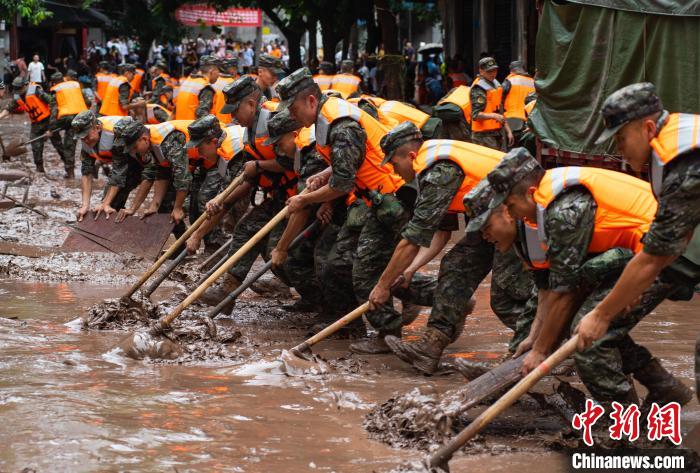 7月4日，萬州區(qū)五橋街道，武警官兵清理街道上的淤泥。　冉孟軍 攝