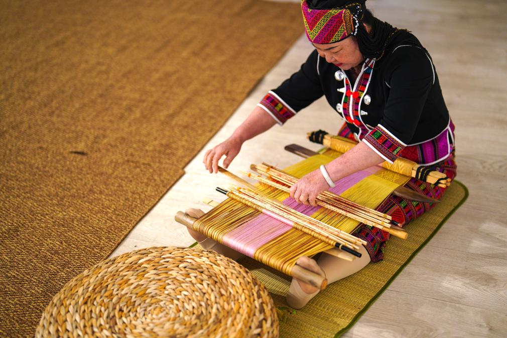 4月17日，黎族傳統(tǒng)紡染織繡技藝國家級代表性傳承人劉香蘭在2023年意大利米蘭設計周上展示黎錦織造技藝。新華社發(fā)