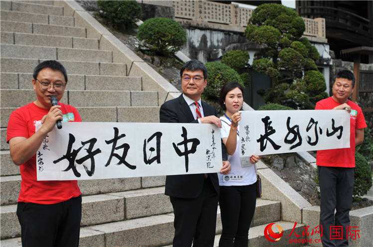 東京中國文化中心主任羅玉泉展示其為本次活動(dòng)書寫的題詞“中日友好，山高水長”。人民網(wǎng) 蔣曉辰攝