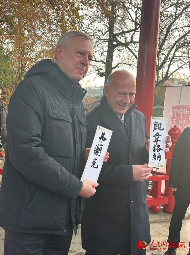 柏林市長(zhǎng)韋格納（右）、動(dòng)物園監(jiān)事會(huì)主席布魯克曼（左）手持中國(guó)文化中心工作人員現(xiàn)場(chǎng)手書(shū)的中文名字。人民網(wǎng)記者 徐馨攝