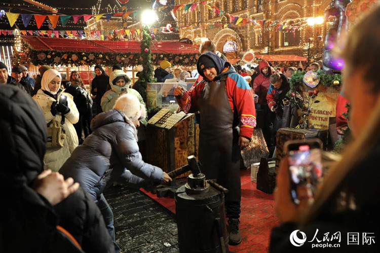 游客在新年集市上體驗(yàn)制作紀(jì)念幣。人民網(wǎng)記者 隋鑫攝