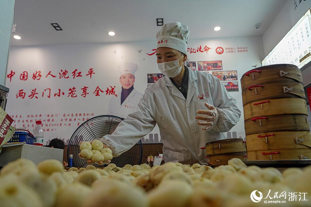 3月31日，在浙江省嵊州市甘霖鎮(zhèn)，嵊州小吃從業(yè)者沈紅平把蒸熟的小籠包晾涼，打包冷藏售賣。人民網(wǎng) 章勇濤攝