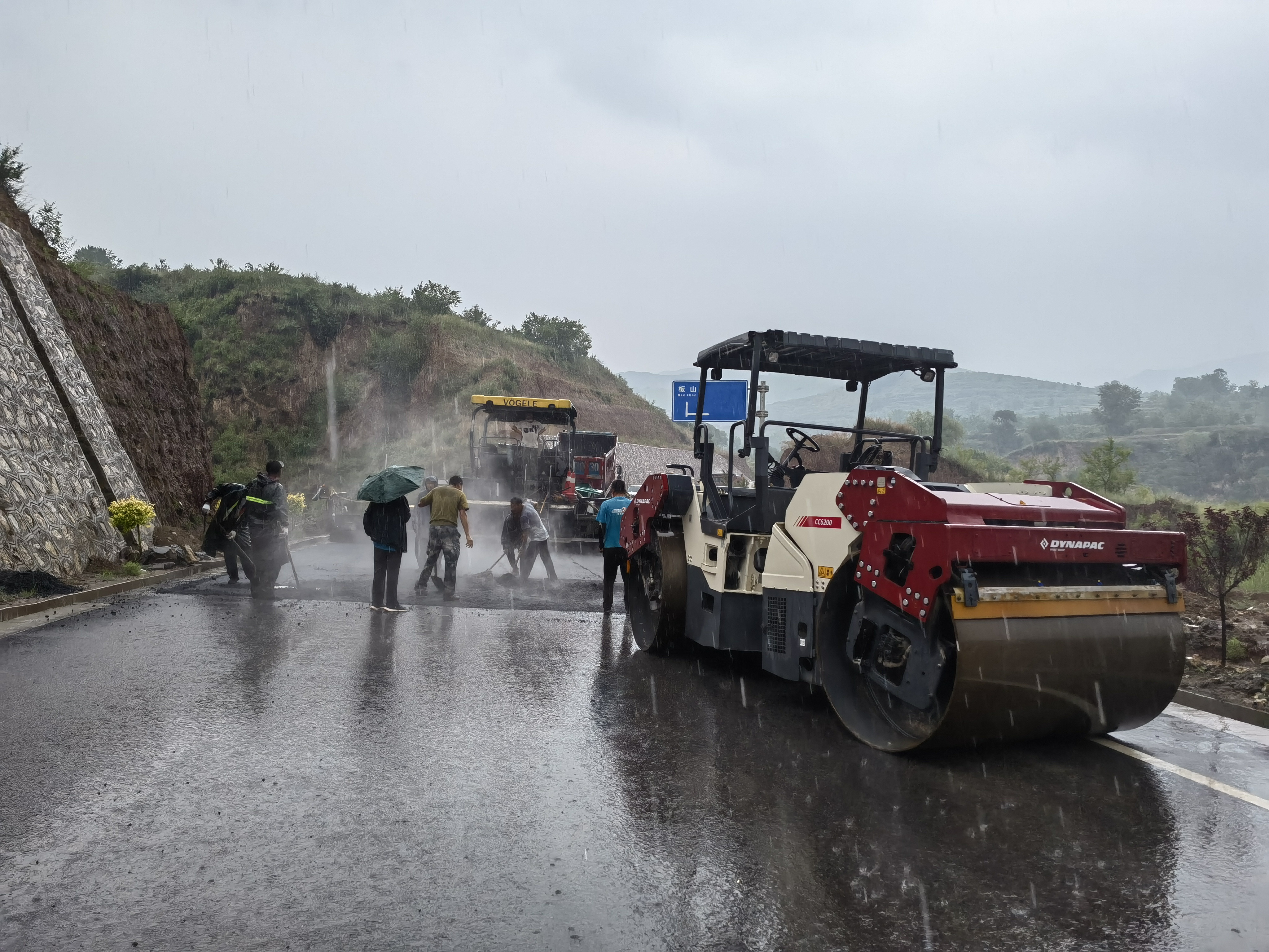 路橋工人在大雨中搶修道路。李華英 攝