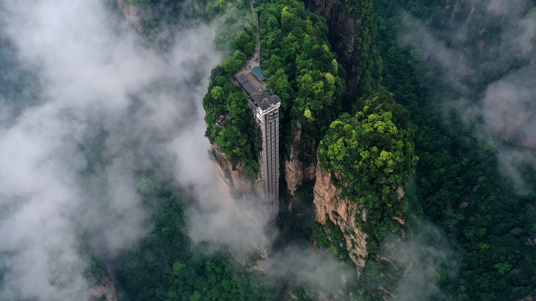 位于張家界武陵源景區(qū)的百龍?zhí)焯蓁偳对谠旗F繚繞的峰林間，雄偉壯觀。吳勇兵攝