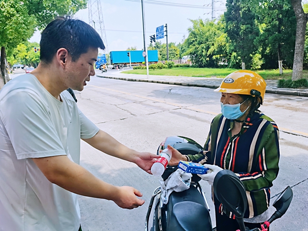 何超為過路的老人送上礦泉水和冷飲。人民網(wǎng)記者 王繼亮攝