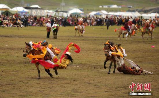 8月4日，四川理塘“八一”賽馬場(chǎng)上演一場(chǎng)精彩的馬術(shù)競(jìng)技比賽，引來上萬民眾和游客觀賽。圖為牧民騎手進(jìn)行五彩凌空競(jìng)技。 中新社記者 劉忠俊 攝