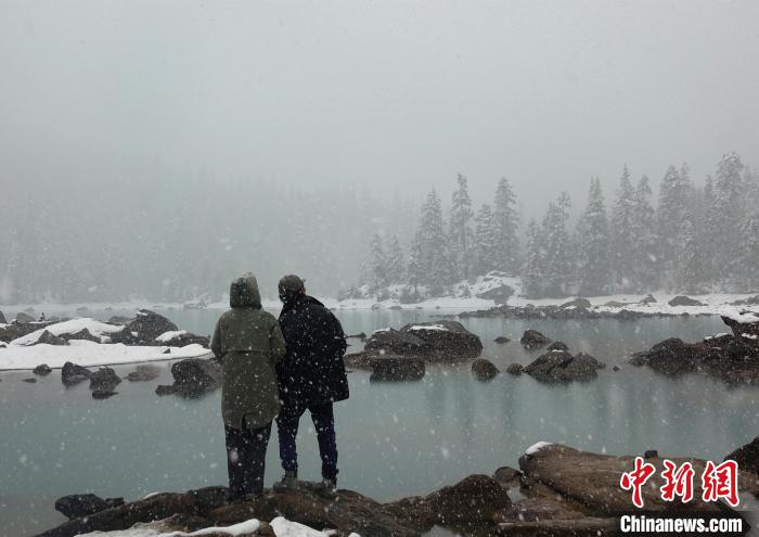 游客欣賞雪中然烏湖。　冉文娟 攝