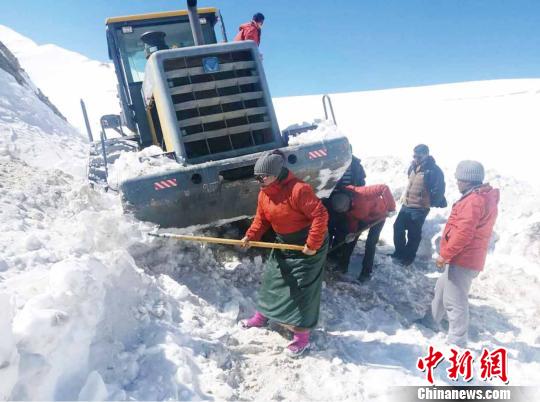 圖為普布卓瑪(左一)與養(yǎng)護工人一起抗擊雪災(zāi)，搶險保通?！“⒗锏貐^(qū)公路養(yǎng)護段供圖 攝