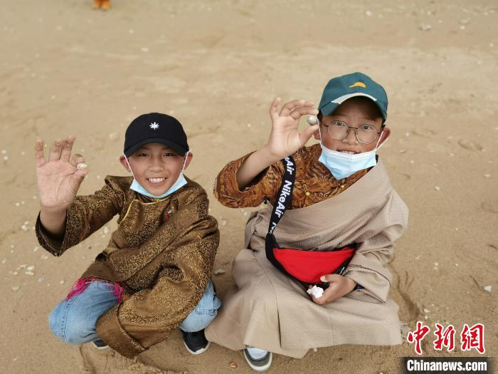 圖為西藏青少年在海邊拾貝殼。西藏航空 供圖