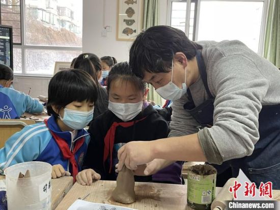 圖為西寧市勞動路小學(xué)教師賈煜與學(xué)生一起制作陶藝。　周瑞辰子 攝