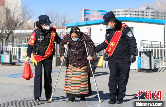 圖為拉薩鐵路公安民警幫助老人進(jìn)站乘車(chē)?！『铲i 攝