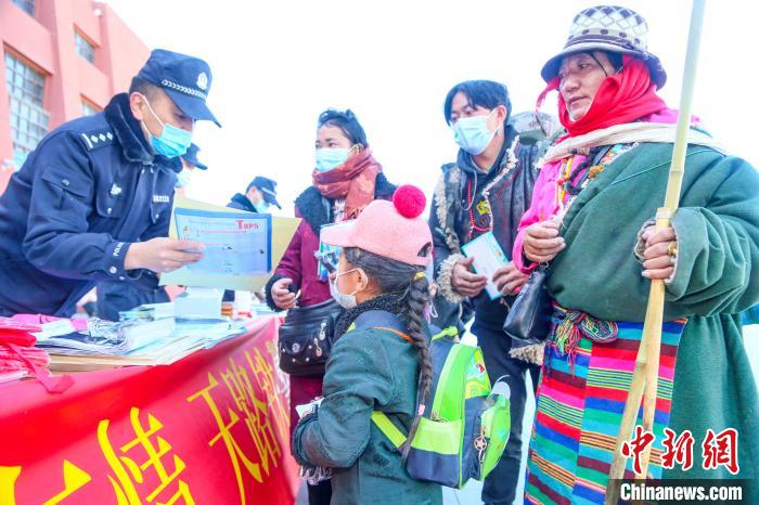 圖為拉薩鐵路公安民警向旅客發(fā)放乘車(chē)安全宣傳資料?！↑S飛 攝