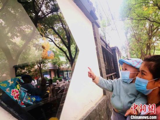 圖為蘭州市民在街頭觀賞刺繡和刻葫蘆的非遺展示。(資料圖) 史靜靜 攝