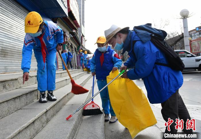 圖為拉薩市小學(xué)生打掃街道?！∝暩聛硭?攝