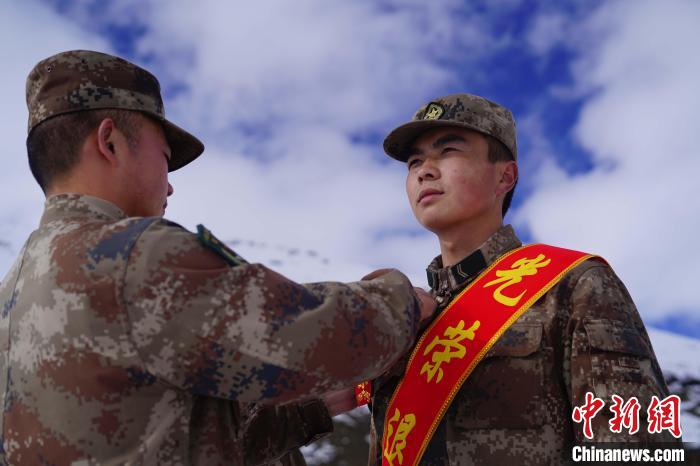 排長(zhǎng)王朝偉(圖左)給退伍老兵佩戴大紅花?！∥鞑厣侥宪姺謪^(qū)某團(tuán)供圖