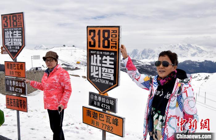 圖為5月14日，西藏林芝色季拉山觀景臺，游客與南迦巴瓦峰合影?！±盍?攝