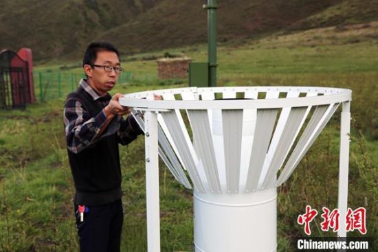 圖為班瑪縣氣象局工作人員在維護藏雪茶基地氣候站。青海省氣象局供圖