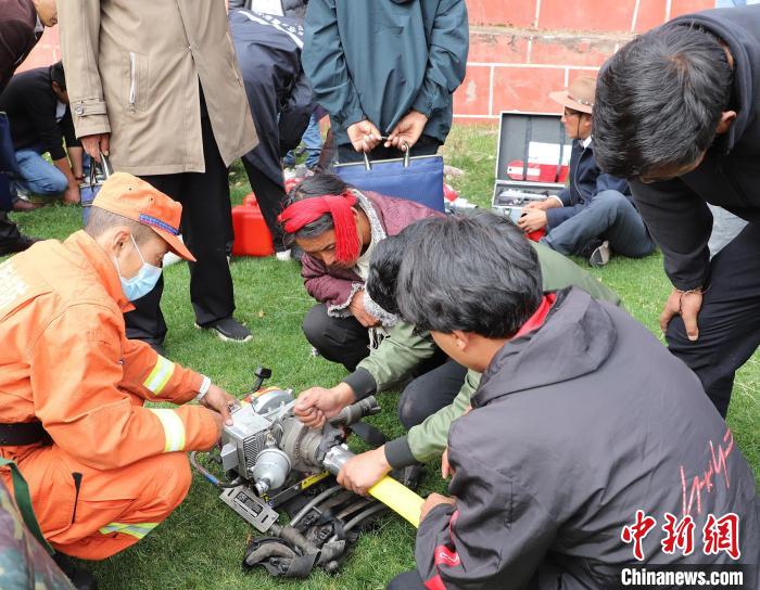 圖為森林消防員為護(hù)林員講解滅火裝備的使用方法。　昌都市森林消防支隊(duì) 供圖