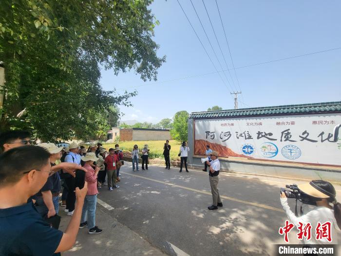 圖為中國地質(zhì)大學(xué)(北京)教授張緒教介紹村落情況。　胡友軍 攝