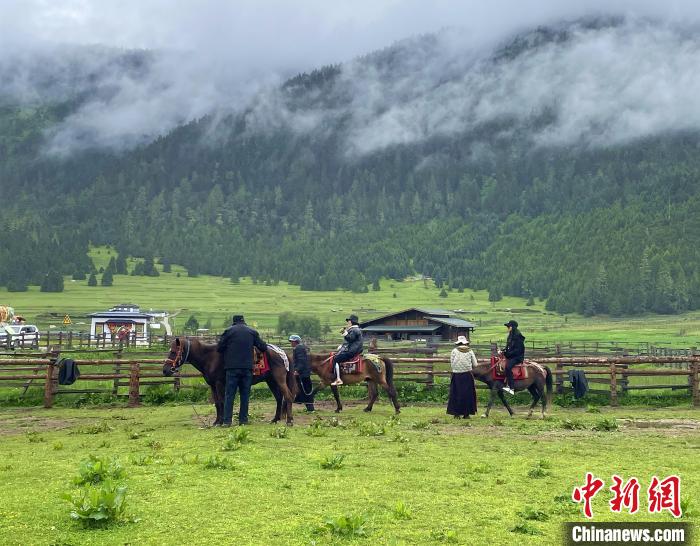 6月10日，游客在魯朗小鎮(zhèn)高山牧場(chǎng)景區(qū)體驗(yàn)騎馬。　冉文娟 攝