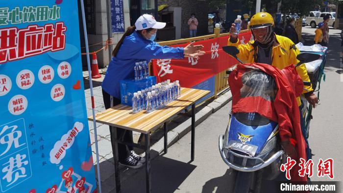 圖為近日，西藏自治區(qū)青年志愿者協(xié)會(huì)志愿者在拉薩街頭向快遞員送水。西藏自治區(qū)青年志愿者協(xié)會(huì) 供圖