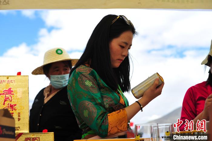 圖為拉薩市民在特色農(nóng)畜產(chǎn)品展示展銷會上選購商品?！垈?攝