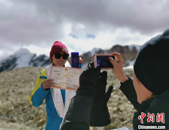 圖為5日，登頂洛堆峰的登山者獲得西藏自治區(qū)登山協(xié)會(huì)頒發(fā)的登頂證明?！垈?攝