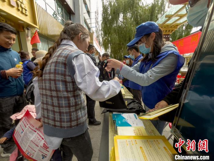 圖為志愿者為市民發(fā)放網(wǎng)絡安全宣傳手冊?！≈x牧 攝