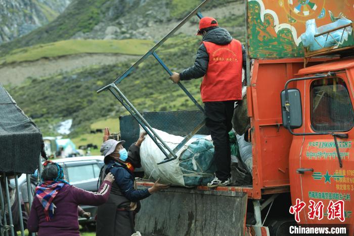 圖為工作人員幫助牧民們卸家具?！÷蹇?攝