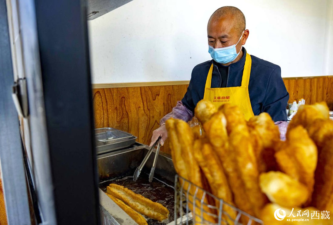 早餐店老板正在炸油條。人民網(wǎng) 次仁羅布攝