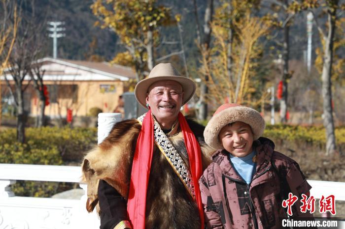 圖為林芝市巴宜區(qū)布久鄉(xiāng)仲果村村民桑杰與孫子一起參加藏歷新年活動?！埩?攝