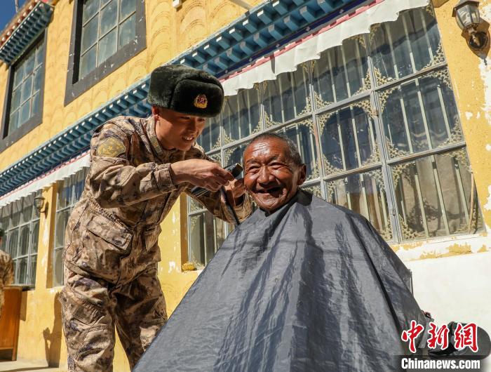 圖為阿里軍分區(qū)某邊防團官兵為駐地群眾理發(fā)迎藏歷新年?！〉┰鰝愔?攝