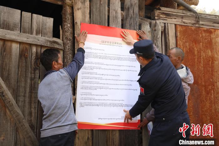 圖為亞?wèn)|邊檢站民警與駐地邊民群眾共同張貼國(guó)家安全知識(shí)教育海報(bào)?！?wèn)|邊檢站 供圖