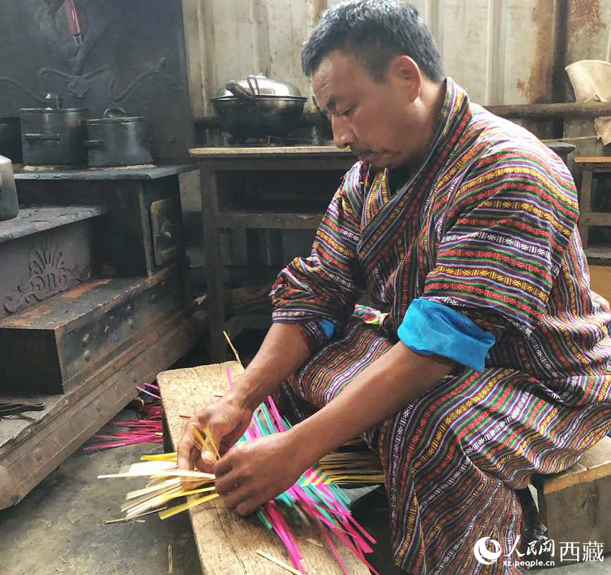 門巴族漢子愛明正在編織藤竹品。